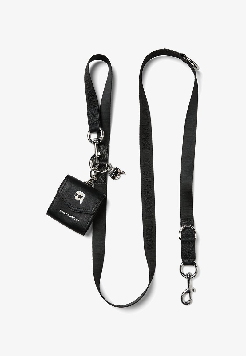 Svart läder mini-väska med en silverlogotyp och dödskalledetalj, fäst vid en svart rem med "KARL LAGERFELD" varumärke och metallaccent.