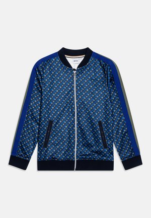 Chaqueta bomber azul con estampado, cremallera frontal, cuello de canalé y bolsillos laterales; presenta mangas a contraste en tonos azules y verdes.