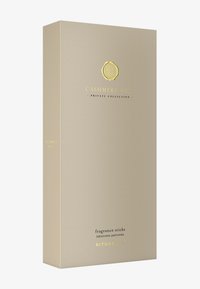 Beige texturerad låda med guldpräglad logotyp och text, märkt "Cashmere Rose Private Collection Fragrance Sticks." Enkelt och elegant design.