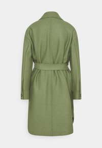 Vihreä villakangastakki, jossa on vyöllinen vyötärö, pitkät hihat ja halkio-kaulus. Ominaisuuksiin kuuluu suora leikkaus ja nappikiinnitys hihansuissa, takanäkymä esitetty.