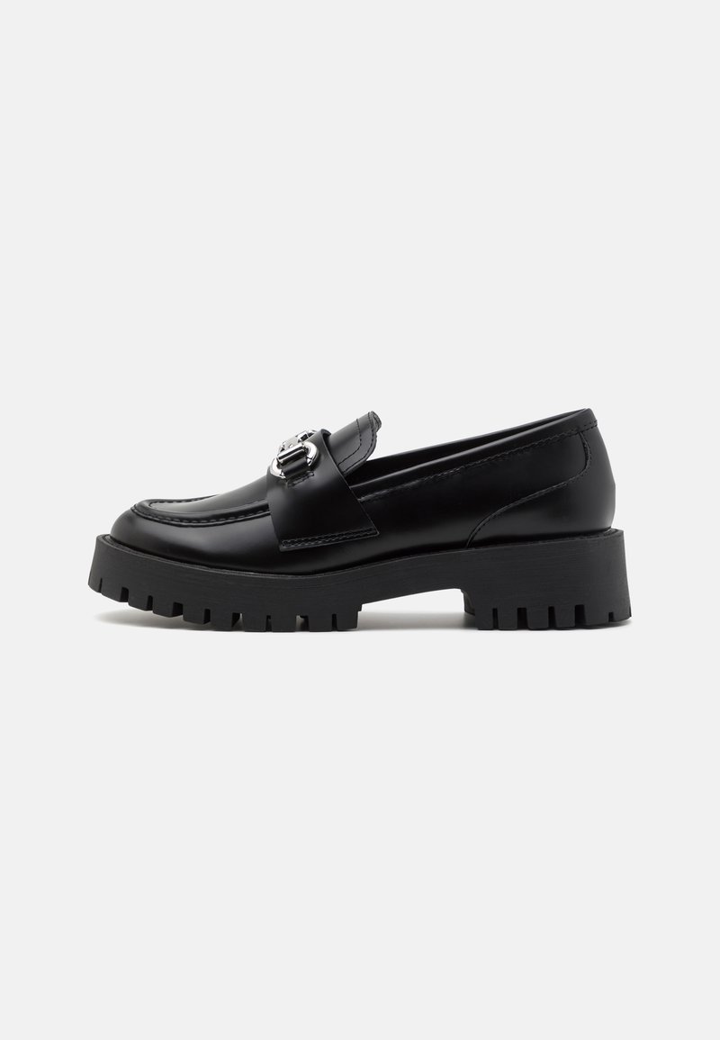 Sorte skinnloafers med en kraftig, riftete såle og en metallisk spenneaksel på stroppen. Glatt tekstur, klassisk design.