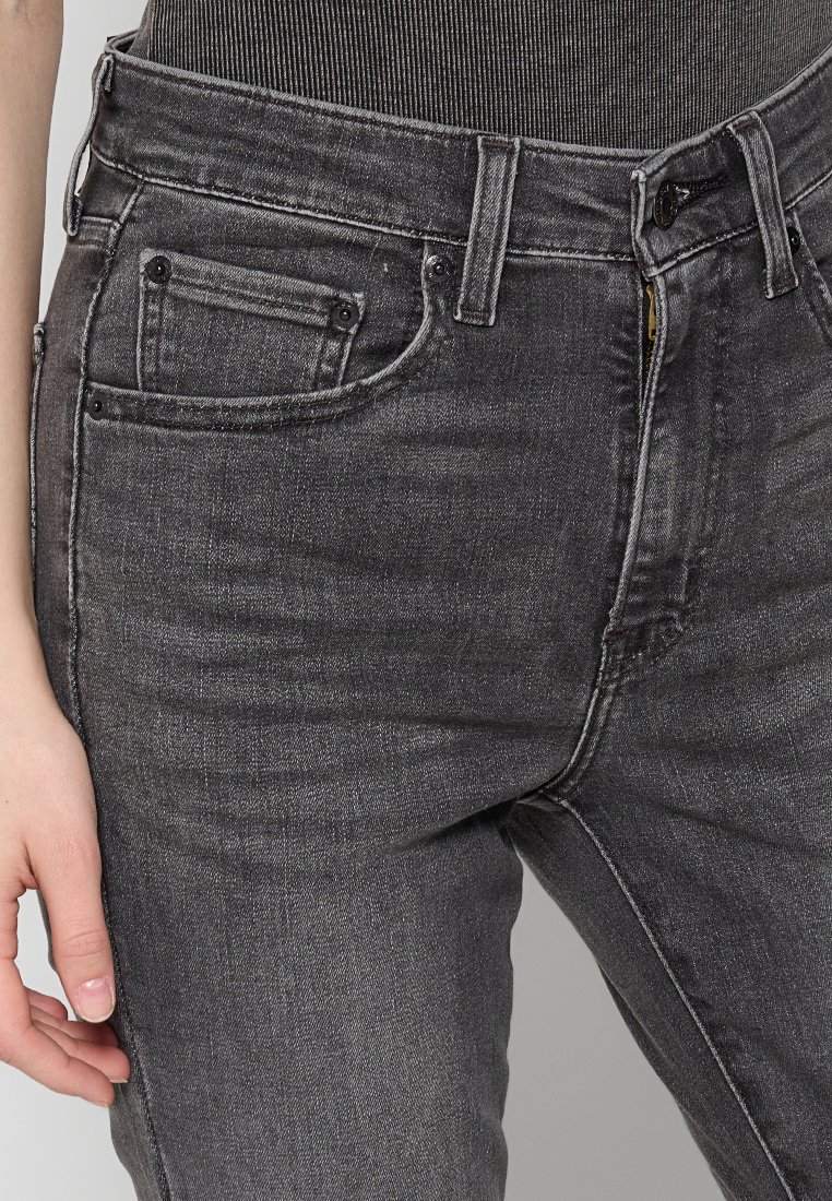 Grijze denim jeans met een getailleerd ontwerp, voorzien van een klein voorvakje, vijf lussen en minimalistische stiksels. Glad oppervlak.