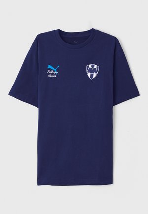 T-shirt en coton bleu marine avec col rond, présentant un logo Puma bleu et un emblème en forme de bouclier blanc avec un détail de lettre sur la poitrine.