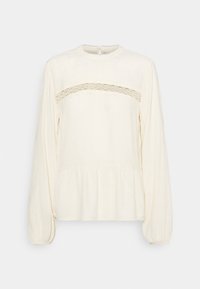 Krémová halenka s dlouhými rukávy a kulatým výstřihem, s krajkovým panelem přes hrudník a nařaseným peplum lemem. Měkká textura.