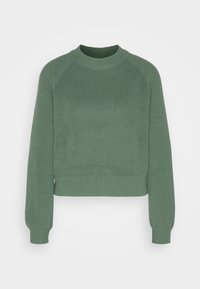 Maglione verde lavorato a maglia con design cropped, texture a coste, scollatura a girocollo e maniche lunghe raglan. Presenta polsini e orlo a coste.