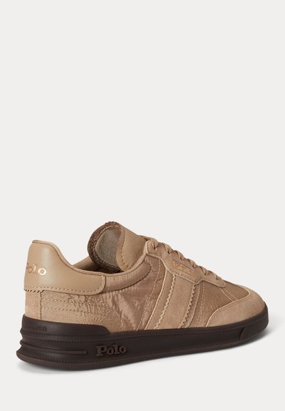 Bézs Polo Ralph Lauren sportcipő nubuk és bőr panelekkel, sötétbarna gumitalppal, arany Polo logóval a saroknál és az oldalon.