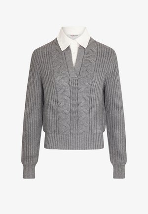 Suéter gris de punto trenzado con escote en V, mangas largas y dobladillo acanalado. Lleva una camisa blanca con cuello debajo.