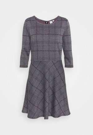 Robe grise avec un corsage ajusté et une jupe évasée, présentant un motif tartan en rouge foncé et blanc. Manches trois-quarts et col rond.