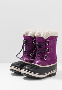 Stivali invernali viola con una parte inferiore in gomma nera. Presentano lacci, una fodera in pelliccia sintetica e una texture orizzontale sulle punte.