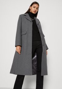 Grå frakk laget av ullblanding, med notched lapel, fem knapper og sidelommer, med en glatt satengligning.