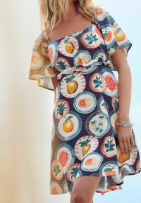 Vestido de manga corta con un vibrante estampado de frutas en patrones circulares, con fondo azul marino, cintura fruncida y tejido ligero.