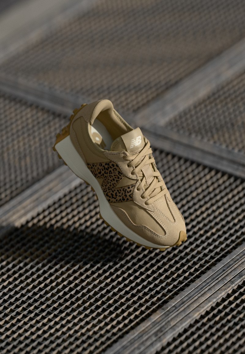 Μπεζ αθλητικό παπούτσι με λεοπάρ σχέδιο, υφασμάτινο άνω μέρος με υφή και χοντρή λευκή ενδιάμεση σόλα. Διαθέτει κορδόνια και ελαστική σόλα.