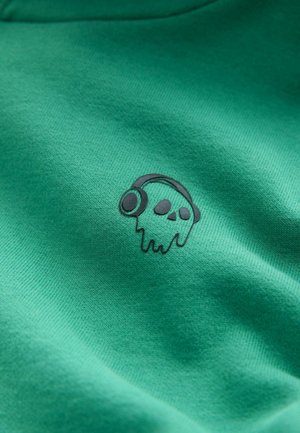 Tissu en coton vert présentant un motif graphique noir d'un crâne dégoulinant portant un casque audio, situé à l'avant. Texture lisse.