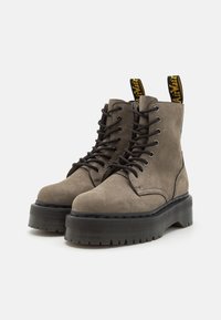 Bottines gris suede avec semelles plateformes en caoutchouc noir, bout rond, devant lacé, et boucle jaune avec texte au dos.