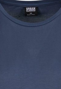 T-shirt Urban Classics bleu marine avec col rond, taille XS, fabriqué en Chine, montrant la texture du tissu et les coutures du col.