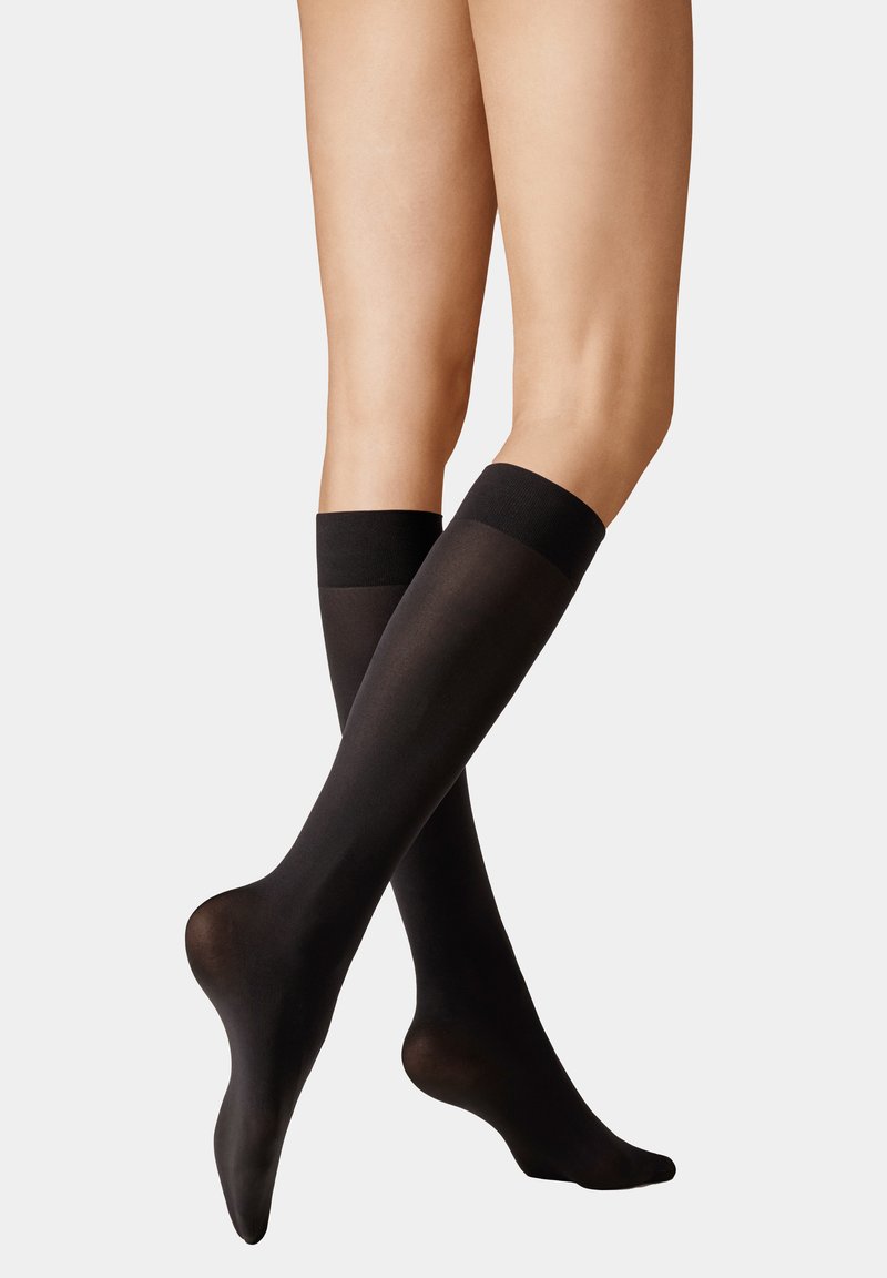 Schwarze knielange Socken mit einer glatten, glänzenden Oberfläche und einem kontrastierenden, einfarbigen schwarzen Bündchen oben, das ein tailliertes und elegantes Design aufweist.