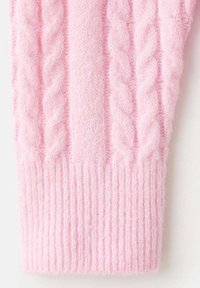 Sezione di pullover lavorato a maglia rosa chiaro con design a trecce e orlo a costine. Texture morbida, con schemi in rilievo ben evidenti.