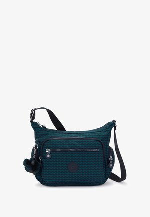 Bolso de hombro de tela en verde azulado oscuro con un patrón geométrico, que cuenta con un compartimento principal con cremallera, un bolsillo frontal y un charm de piel extraíble.