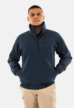 Chaqueta azul marino con cremallera hecha de un material ligero y suave. Cuenta con un cuello alto, puños elásticos y un logo en el pecho.