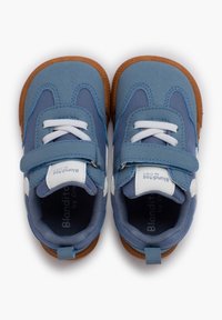 Scarpe per bambini di colore blu con una parte superiore testurizzata, dettagli bianchi, una fascia in velcro e una suola in gomma marrone con una forma arrotondata.