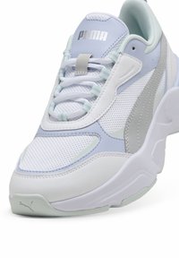 Sneaker bianca con dettagli blu chiaro e grigi. Presenta pannelli in rete, pelle texturizzata, lacci piatti e una suola in gomma con dettagli del logo.