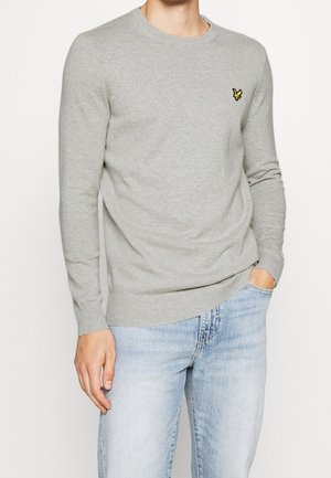 Maglione grigio chiaro in morbido tessuto a maglia, con collo rotondo e polsini a costine. Ricamo giallo del logo sulla parte superiore sinistra del petto.