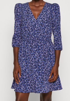 Petite robe violette avec un motif imprimé léopard, décolleté en V, manches bouffantes, taille élastique et ourlet évasé. Le tissu semble léger.