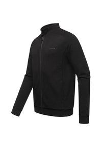Chaqueta negra con cremallera, hecha de una tela suave, que presenta un alto cuello, mangas largas y un parche con el logo en el lado izquierdo del pecho. Incluye dos bolsillos laterales.