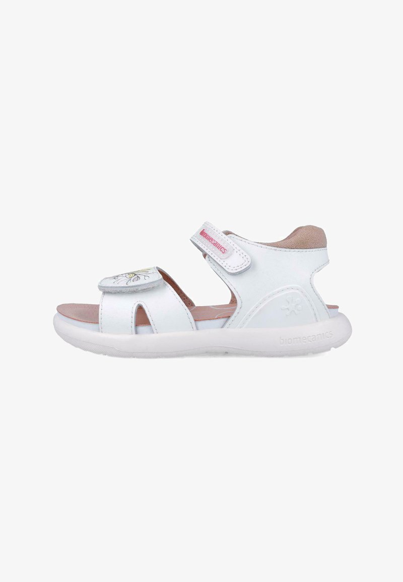 Sandal bianca con numerosi fori, un design floreale sulla cinghia, chiusura regolabile con Velcro e suola imbottita. Presenta un logo sul lato.