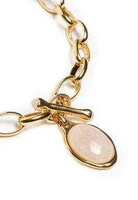 Naszyjnik z łańcuszka w kolorze złota z owalnym wisiorkiem z różowego kwarcu, o gładkiej fakturze i polerowanym wykończeniu. Wyróżniające się zapięcie i design ogniw.