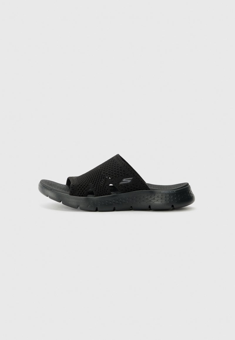 Zwarte slip-on sandalen met een textuur van gaas aan de bovenkant, open teenontwerp en een flexibele zool met subtiele branding aan de zijkant.