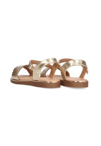 Sandalias doradas con correas anchas, un diseño texturizado y una suela marrón. Presentan un hebilla ajustable y acentos cortados para ventilación.