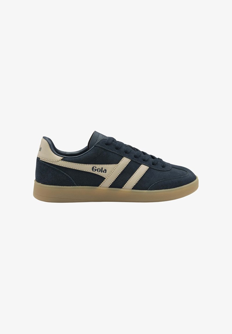 Baskets Gola en daim bleu marine avec des rayures beige, une languette de talon beige, une semelle beige, et des lacets noirs, vue latérale sur fond blanc.