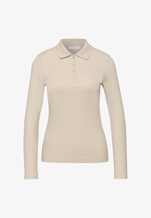 Polo beige à manches longues avec boutons en forme de cœur, texture côtelée et col, présenté sur un fond blanc.