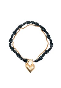 Collar de cuentas de piedra preciosa negra con una cadena de oro trenzada y un colgante en forma de corazón dorado, que presenta una textura suave y un acabado pulido.
