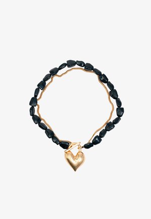 Czarny naszyjnik z kamieni szlachetnych z plecionym złotym łańcuszkiem i złotym zawieszką w kształcie serca, o gładkiej teksturze i polerowanym wykończeniu.
