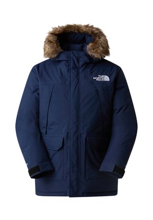 Námořnická modrá parka s odnímatelnou umělou kožešinou na kapuci, několika předními kapsami, žebrovanými manžetami a zapínáním na zip. Obsahuje logo na hrudi.