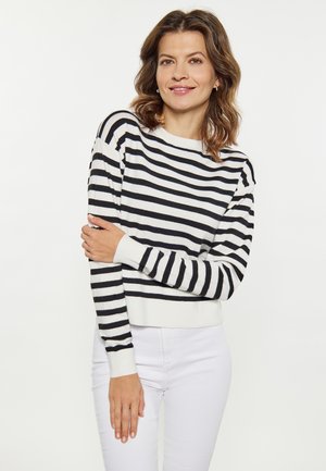 Pulover rayat în alb și negru, cu guler tip barcă și mâneci lungi. Materialul pare moale; designul este relaxat și scurt.