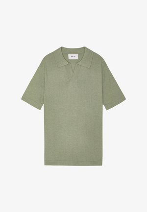 Kortärmad polo i ljus olivgrön, tillverkad av ett mjukt tyg. Har en klassisk krage med V-halsning och rak fåll.