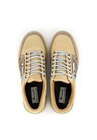 Sneakers beige realizzati in suede e tessuto, con lacci azzurri chiari, design della punta perforato e un pannello laterale con un motivo colorato.
