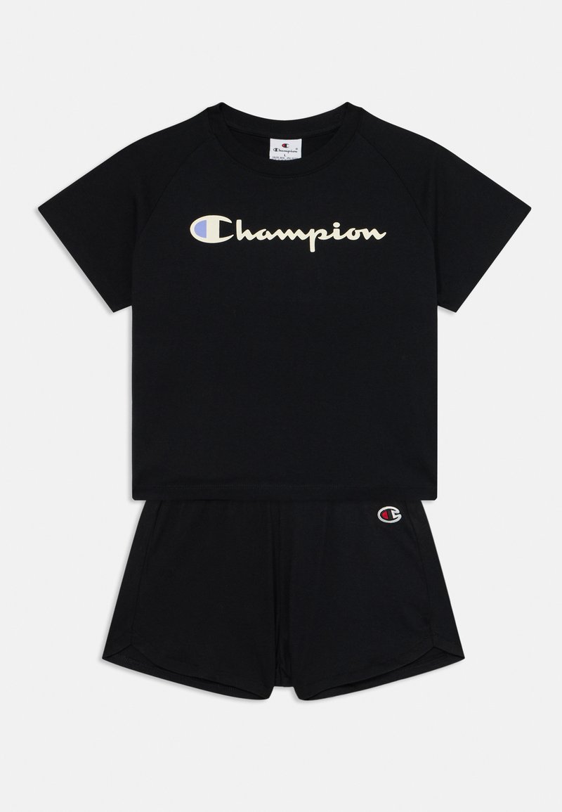 Črni bombažni komplet dveh delov, ki vključuje majico s kratkimi rokavi z napisom "Champion" v kurzivni pisavi in ustrezne hlače s podrobnostmi logotipa na robu.