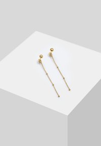 Guldørehængere med en sfærisk stud og hængende kæder med små perler i enderne. Enkel, elegant design.