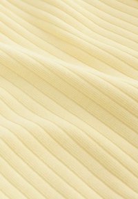 Tela amarilla clara acanalada con una textura suave con rayas alternadas elevadas y planas, ideal para ropa o tapicería.