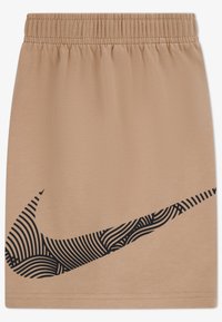 Μπεζ αθλητική φούστα με ελαστική μέση. Διαθέτει μεγάλο μαύρο λογότυπο Nike με σχέδιο στο κάτω δεξί μέρος. Μαλακό, λεία υφή υφάσματος.