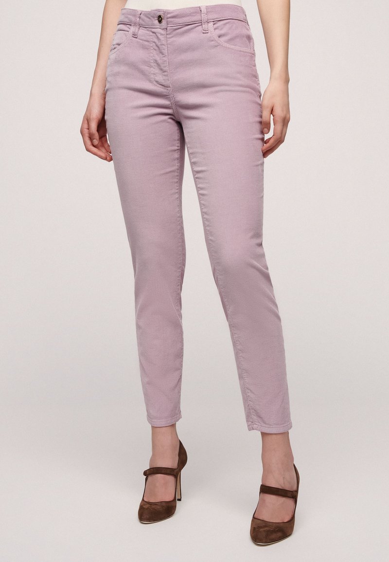 Svetlo vijolične slim-fit chinos hlače z teksturirano tkanino, petimi žepi in sprednjim gumbom. V kombinaciji z rjavimi čevlji z visoko peto.