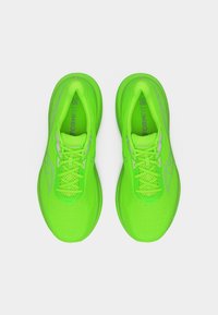 Ζευγάρι από νεον πράσινα παπούτσια για τρέξιμο Saucony με κορδόνια και πέλματα «FORMFIT», εμφανιζόμενα από πάνω σε λευκό φόντο.