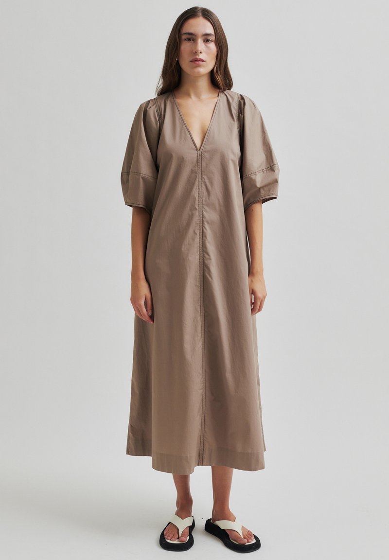 Braunes Baumwollkleid mit V-Ausschnitt, puffierten kurzen Ärmeln und gerader Silhouette. Das Design verfügt über einen Frontreißverschluss und seitliche Schlitze.