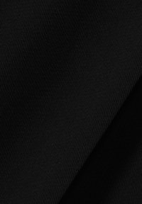 Primer plano de tela negra acanalada con finas líneas verticales, mostrando la textura y detalles del pliegue.