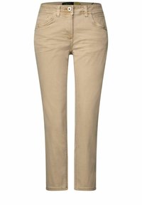 Jeans beige de denim con corte slim, que cuentan con cinco bolsillos, cremallera frontal y cierre de botón metálico. Textura suave, con un desgaste mínimo.