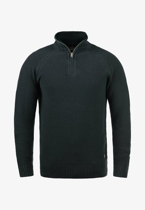 Mørkegrønn strikket genser med høy krage og kvart glidelås, med et teksturert mønster og ribbestrikkede mansjetter og hem.